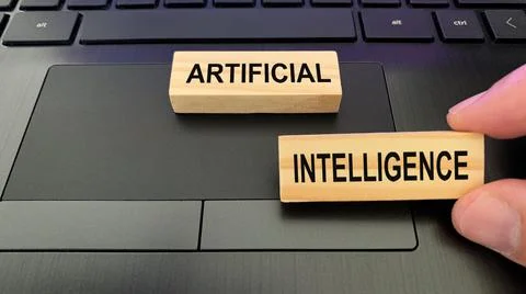 Artificial intelligence text on wooden blocks with laptop background. Stock Photos