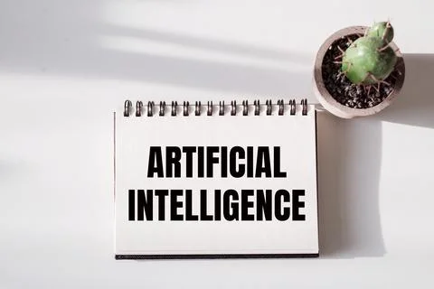 Artificial Intelligence text written on a notebook lying on white surface nex Stock Photos