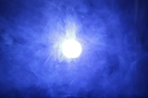 Artificial magic smoke in blue light on black background Stock Photos
