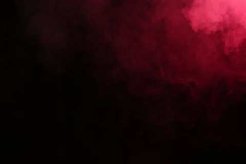 Artificial magic smoke in red light on black background Foto stock