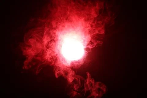 Artificial magic smoke in red light on black background Foto stock