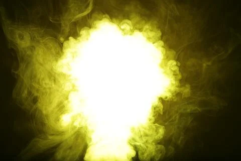 Artificial magic yellow light illuminates smoke on dark background Stock Photos