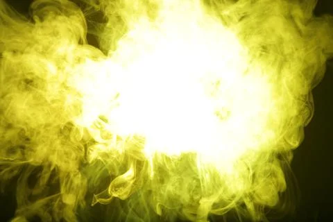 Artificial magic yellow light illuminates smoke on dark background Stock Photos