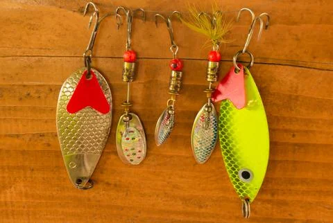 Artificial metal baits on a wooden background. Homemade fishing gear. baits f Stock Photos