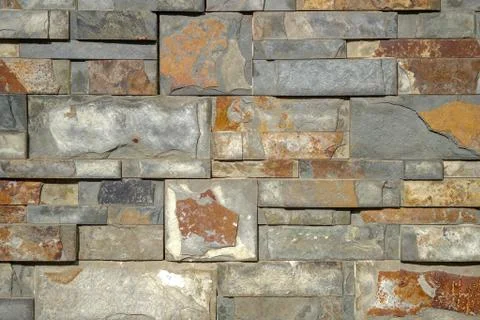 Artificial ocher decorative bricks wall of natural rock stones Stock Photos