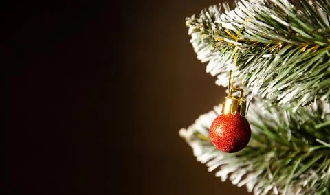 Artificial pine branches in the snow with red Christmas tree ball ornaments. Stock Photos