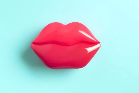 Artificial red lips shape on blue background. Stock Photos