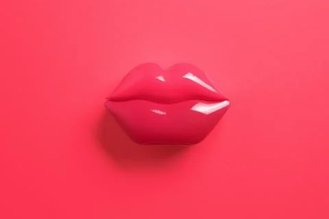 Artificial red lips shape on red background. Flat lay. Beauty, care, perfec.. Stock Photos