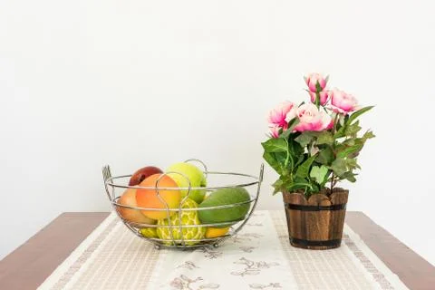Artificial rose bouquet and Artificial fruit in basket Stock-Fotos