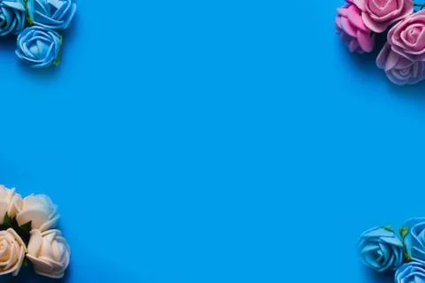 Artificial roses on a blue background frame for text. copy space Stock Photos
