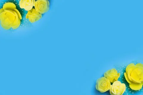 Artificial roses on a blue background frame for text. copy space Stock Photos