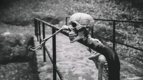 Artificial skeleton looking away resting parapet Foto stock