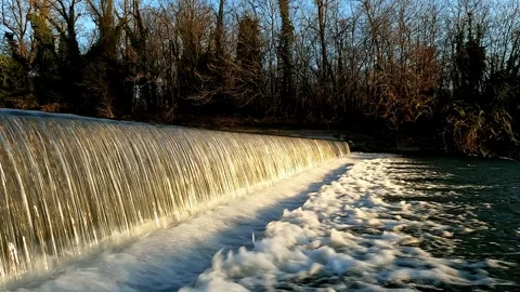 Artificial waterfall with flowing water in the sunset light Stock Footage 304813176