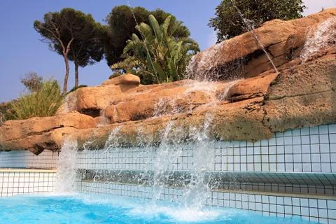 Artificial waterfall in the pool. Stock Photos