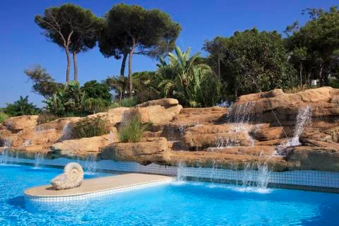 Artificial waterfall in the pool. Stock Photos