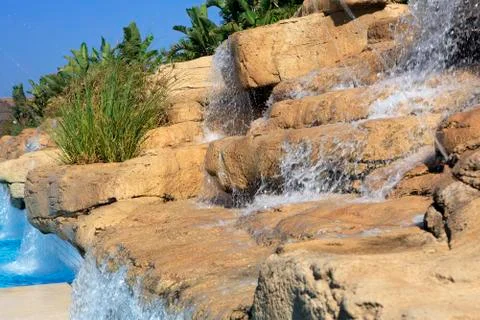 Artificial waterfall in the pool. Stock Photos