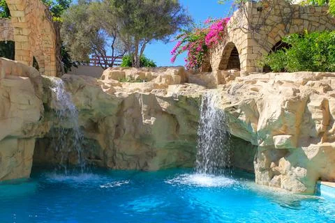 Artificial waterfall in swimming pool Stock Photos