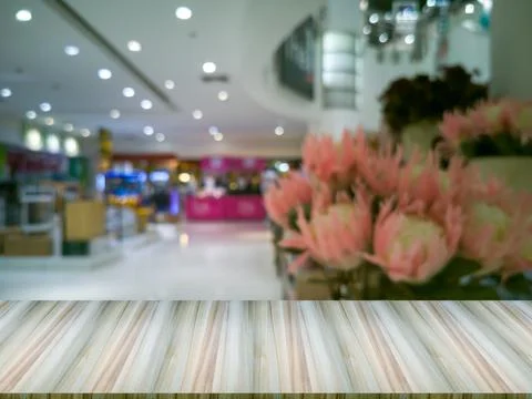 Artificial wood table in front. The bale background with flowers on the right Фото