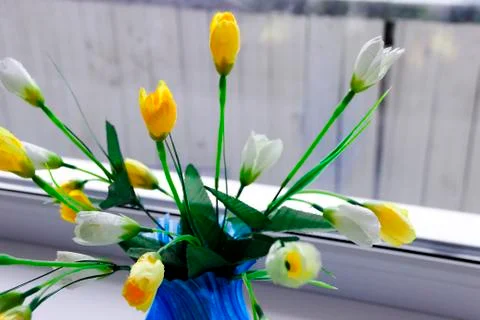 Artificial yellow tulip flowers at blue vase Stock Photos