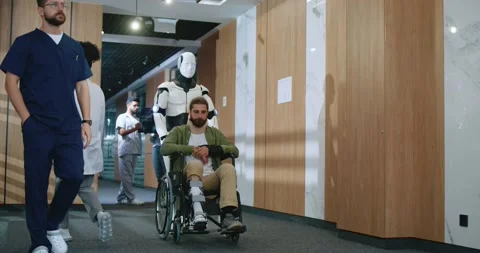 Artificially intelligent robot nurse helping injured young male patient in Stock Footage 256170934