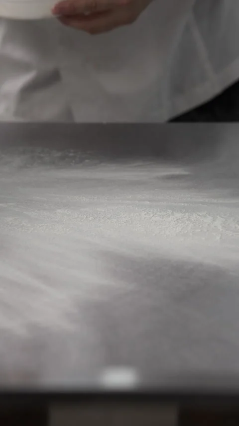 Artisan baker chef sprinkles flour on work surface preparing dough for bread Stock-Footage 319037362