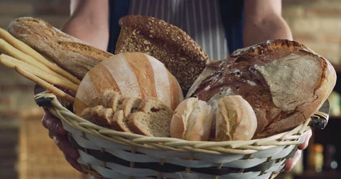 Artisan baker presenting in camera basket with assortment of variety bread Stock Footage 194452802