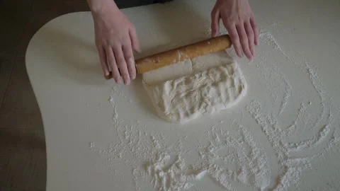 Artisan baker rolling dough on floured surface Stock Footage 339973095