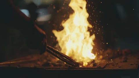 Artisan Blacksmith Forging Hot Metal in Fiery Workshop with Sparks Stock Footage 339751461