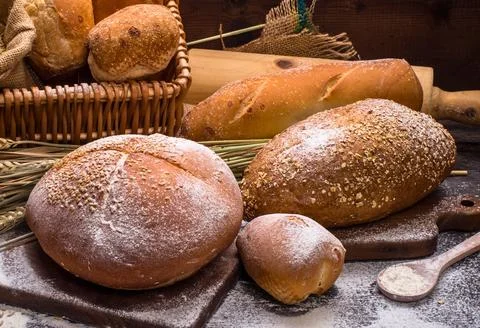 Artisan bread and baking tools displayed on a rustic surface Stock Photos