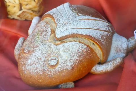 Artisan bread crafted in the shape of a frog, displayed on red fabric. the un Stock Photos