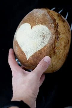 Artisan bread in hand on black background Stock Photos