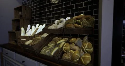 Artisan breads displayed in rustic wooden crates at a bakery 库存插图