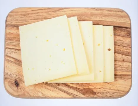 Artisan cheese block with knife on rustic wooden board isolated on white ba.. Stock Photos