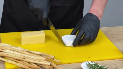 Artisan Cheese Cutting on Yellow Board Stock Footage 256972817
