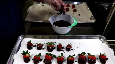 Artisan chocolate maker dipping strawberries for Valentine's Day. Stockbeeldmateriaal 102813675