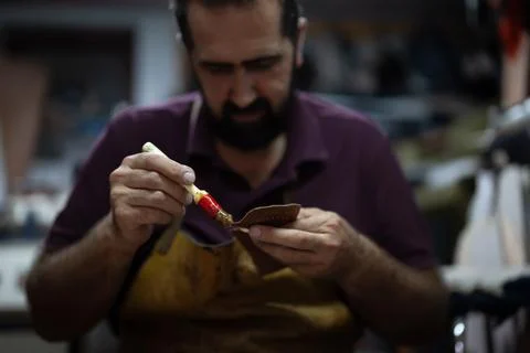 Artisan chocolatier at work, carefully applying glaze to a chocolate piece with Stock Photos