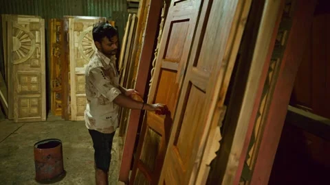 Artisan coats timber sheet with precision inside shop Stock Footage 313666321