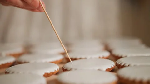Artisan cookie decorating technique showcased. Focused shot of baker applying Stock Footage 346388990