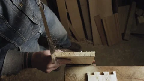 Artisan cuts out a dovetail on a wood board with a hand saw. handmade carpentry Видео 166340999