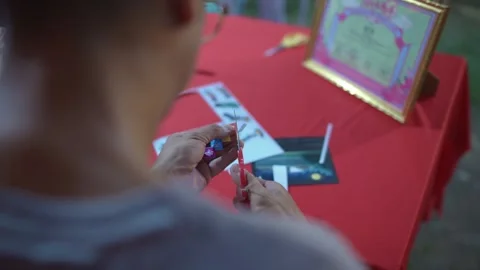 Artisan cutting a decorative paper shape with scissors Video stock 346553954