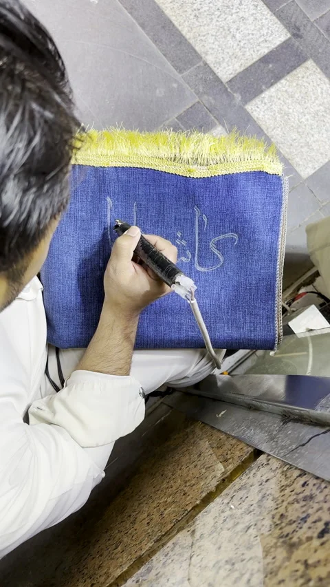 Artisan Engraving Custom Arabic Name on Blue Prayer Mat Stock Footage 332298758