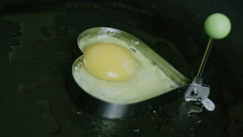 Artisan food view of cracking an egg into a heart mold 스톡 사진