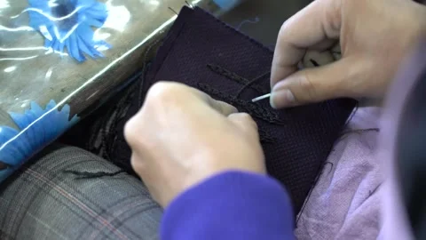 Artisan hand stitches a row of decorative loops on thick indigo cotton for a Vídeo Stock 346737701