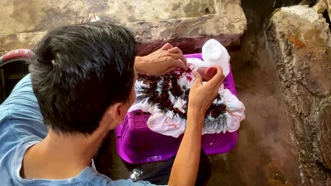 Artisan Hands Applying Liquid Dye Directly on Tied Fabric Stock-Footage 336796692