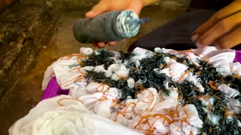 Artisan Hands Applying Liquid Dye Directly on Tied Fabric Stock-Footage 336796693