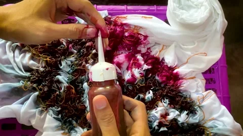 Artisan Hands Applying Liquid Dye Directly on Tied Fabric Stock-Footage 336796749