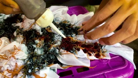 Artisan Hands Applying Liquid Dye Directly on Tied Fabric Stock-Footage 336796787