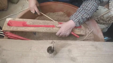 Artisan hands rolling and shaping traditional red incense sticks in powder Stock Footage 331550897