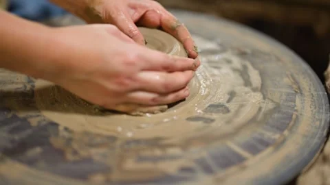 Artisan Hands Shaping Wet Clay on a Spinning Pottery Wheel Stock Footage 341300704