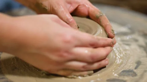Artisan Hands Shaping Wet Clay on a Spinning Pottery Wheel Stock Footage 341454913